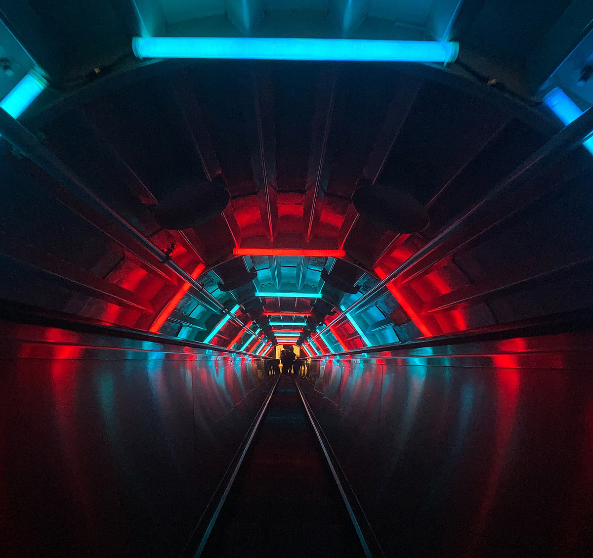 Eine Rolltreppe im dunkeln mit NEON Beleuchtung